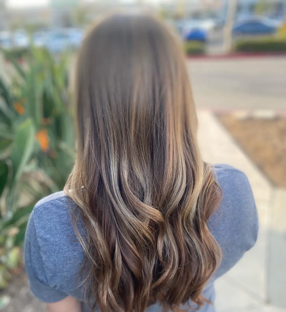 Long brunette hair with soft caramel ribbons, curled at the ends