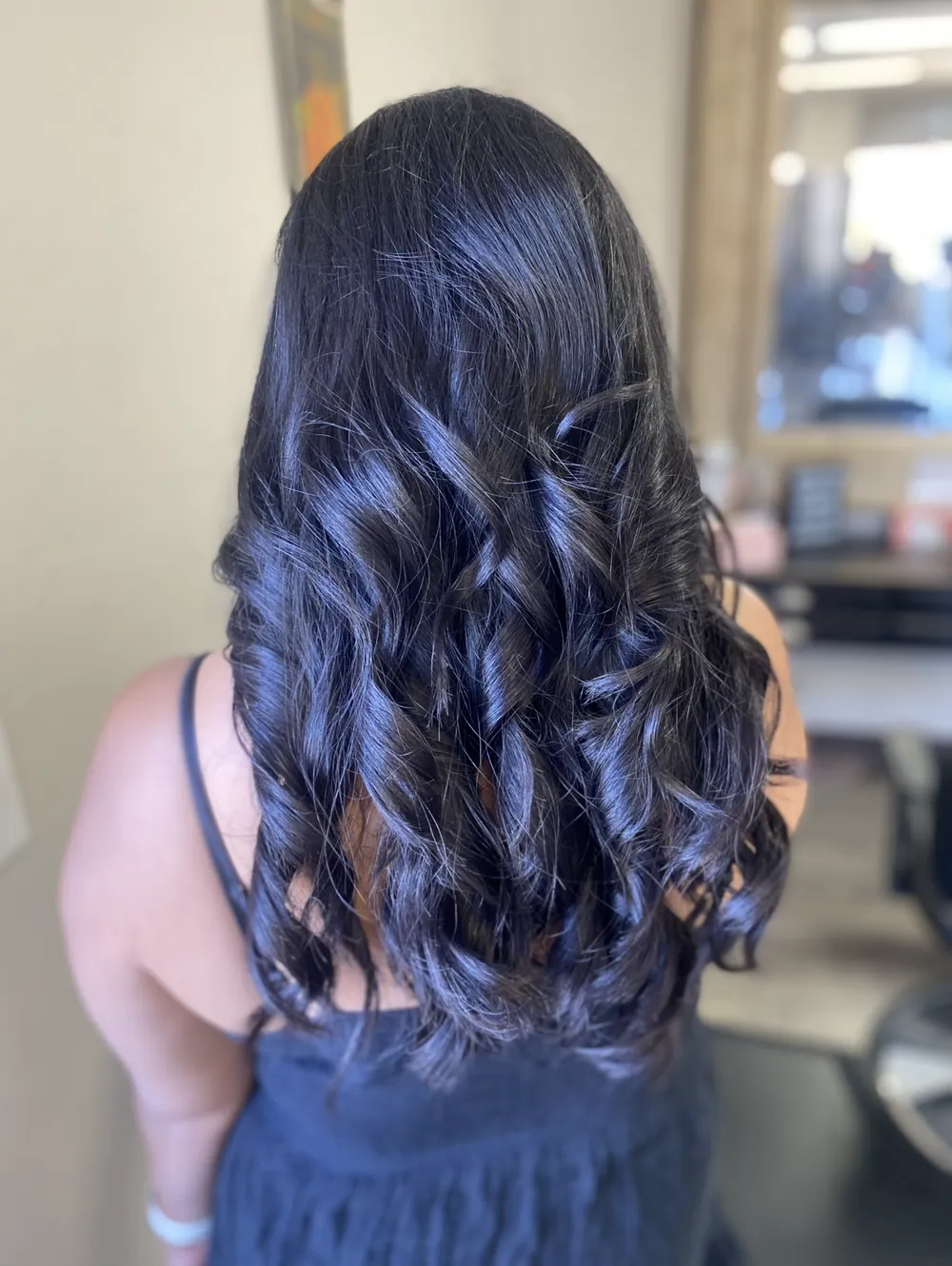 Glossy black hair set in loose curls