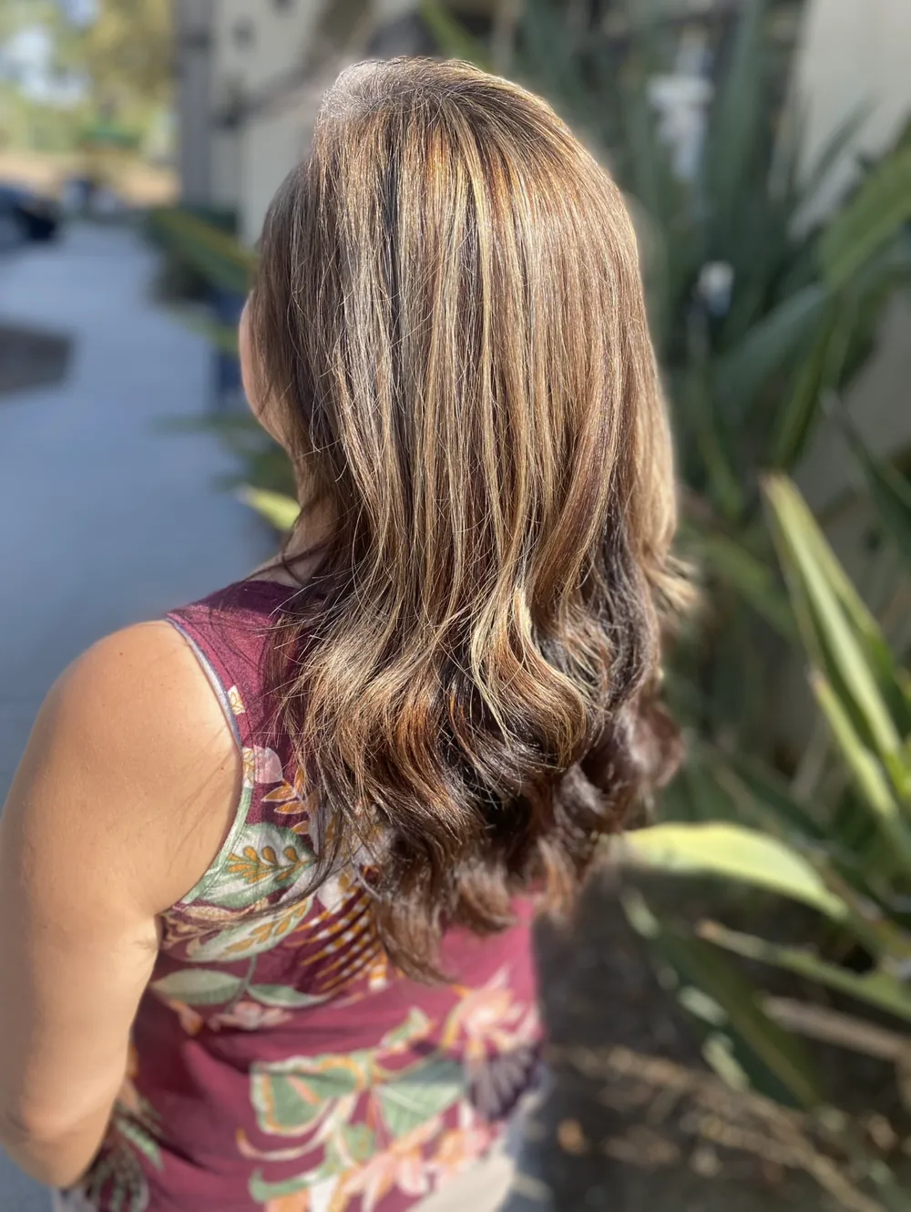 Shoulder-length brown hair with caramel highlights and soft waves
